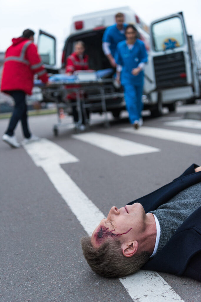 doctors running to wounded middle aged man lying on a street